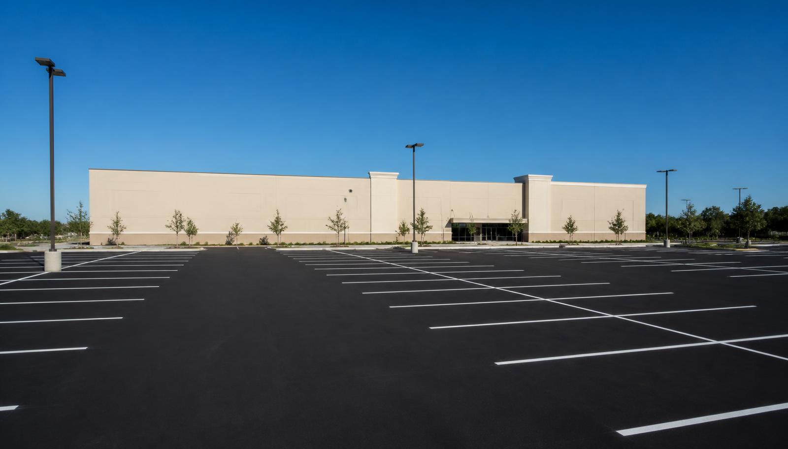 Freshly sealcoated commercial parking lot with new white striping after a Central Valley maintenance cycle.