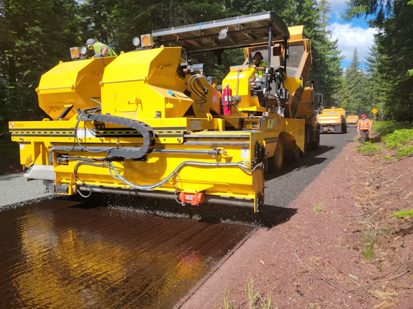 Completed asphalt road paving with proper drainage.