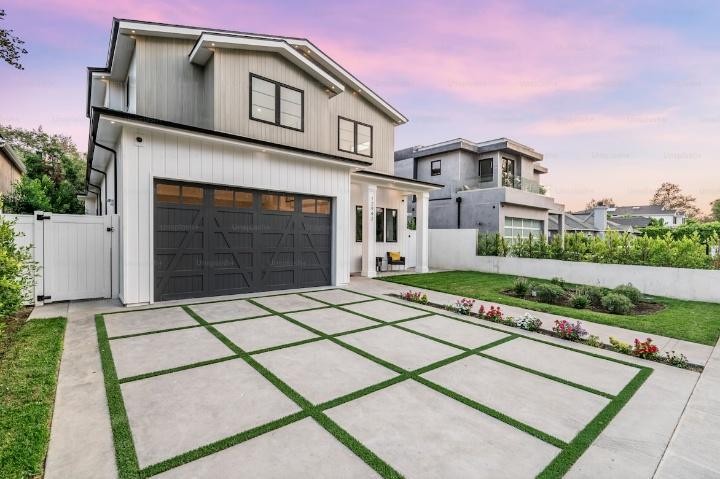 Contemporary residential property showcasing a custom concrete walkway in California with large square slabs and landscaped borders.