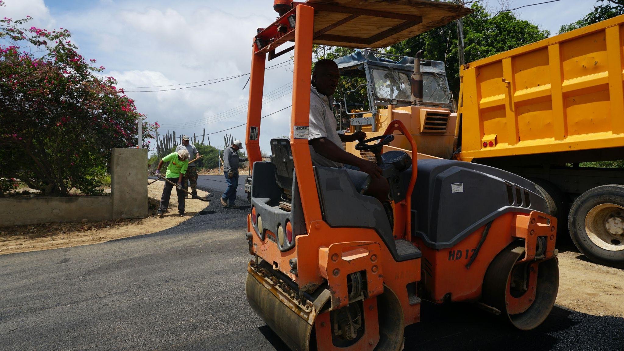 A paving crew uses heavy equipment to finish a newly paved road, supporting asphalt crack repair in Clovis.