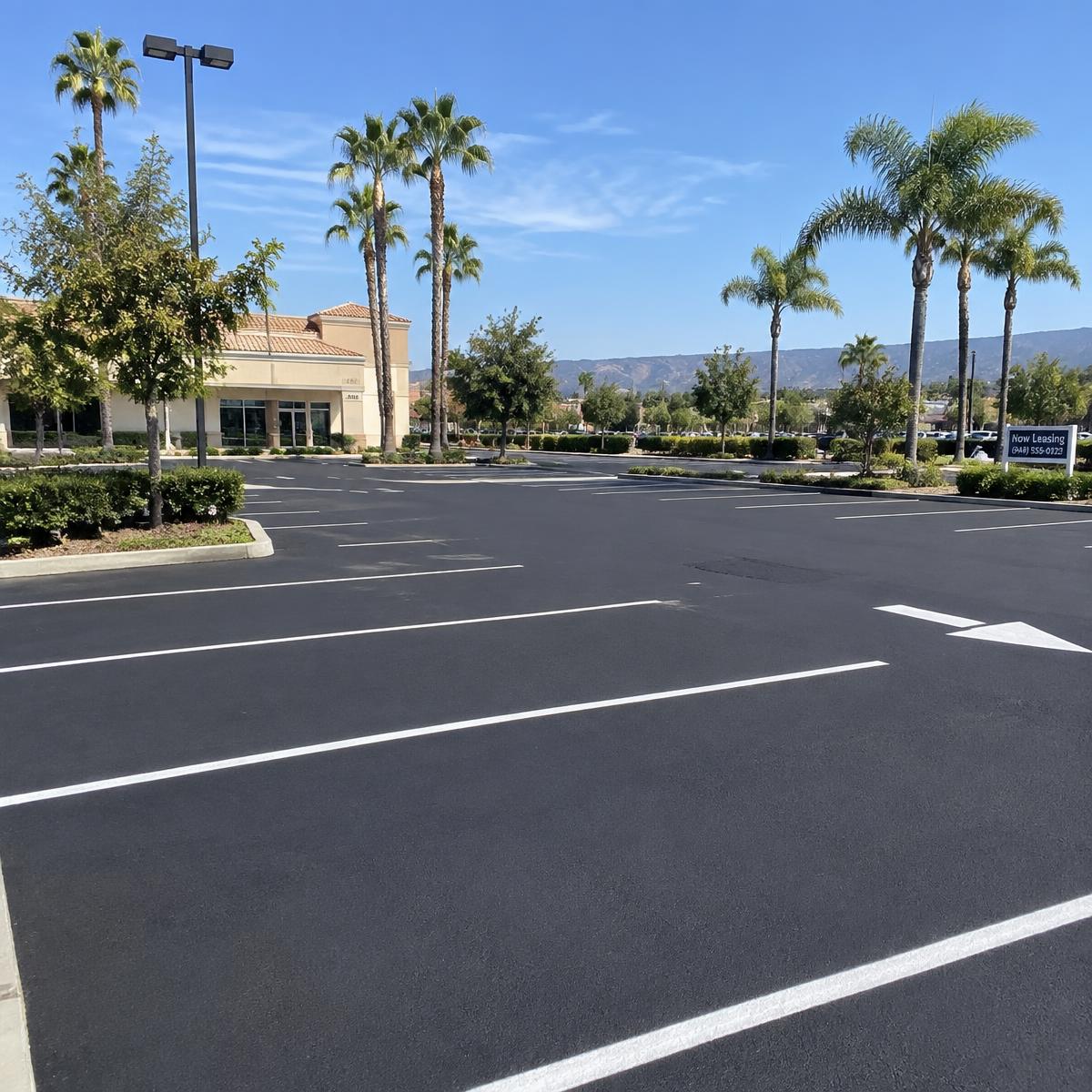 Commercial parking lot resurfacing in California with newly paved asphalt.