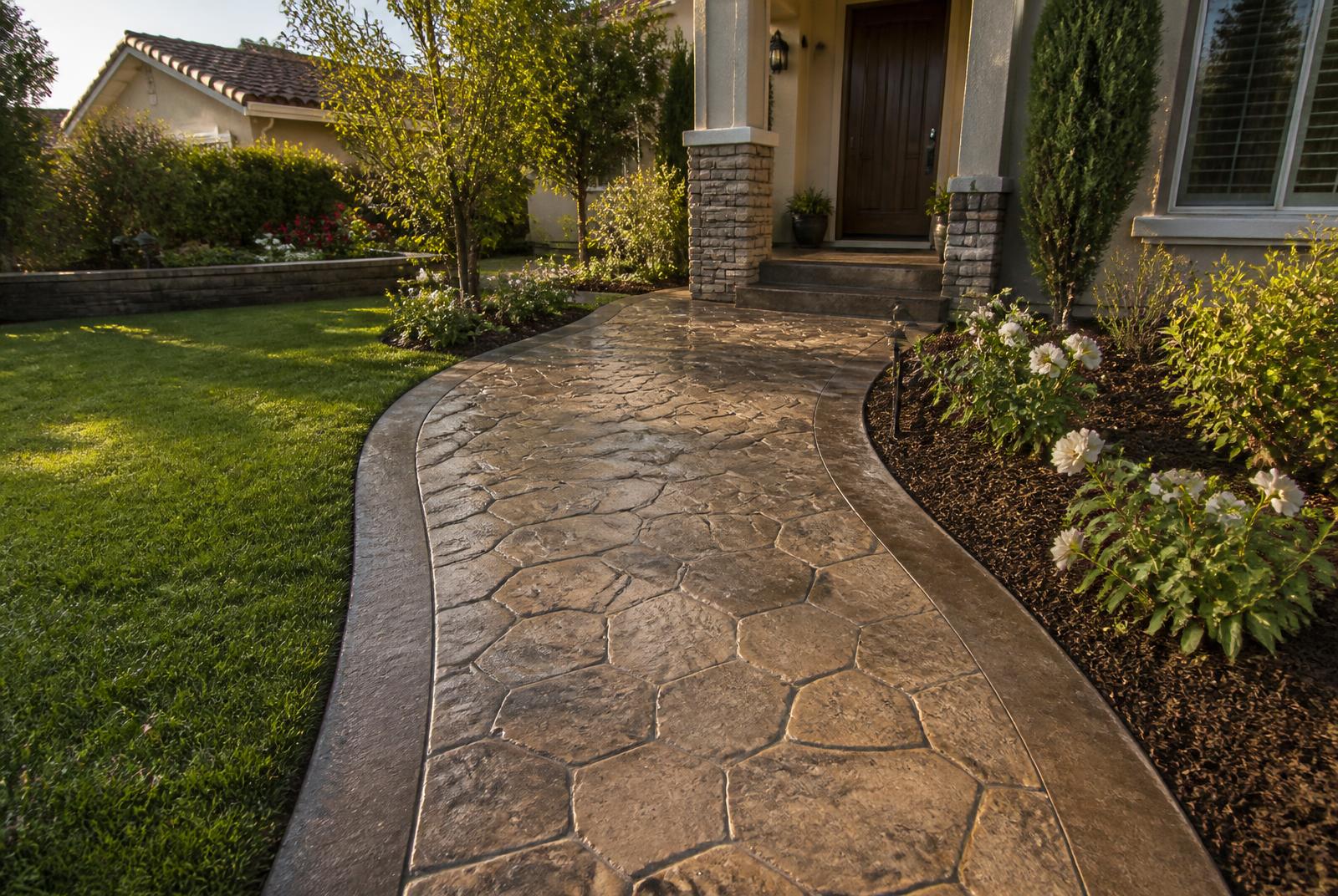 Stamped concrete walkway with a contrasting darker border leading to a front porch